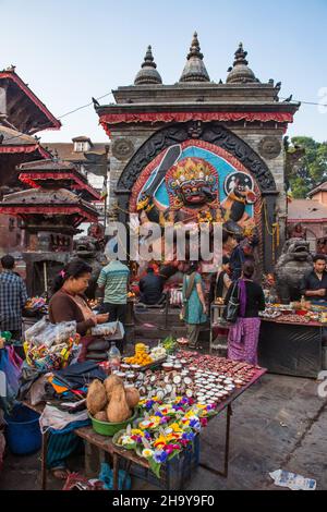 Les vendeurs vendent des offres au sanctuaire hindou du Kala ou Black Bhairab à Durbar Square, Kathamandu, Népal.Le Bhairab noir est la Inc destructive Banque D'Images