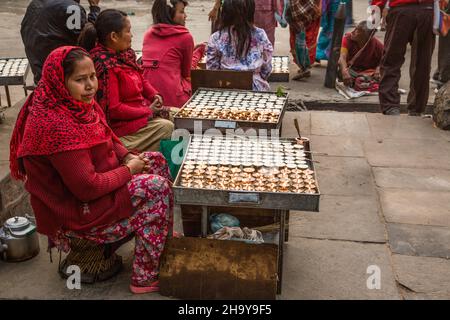 Des femmes hindoues vendent des lampes à beurre à l'entrée du complexe du temple de Swayambhunath à Katmandou, au Népal. Banque D'Images