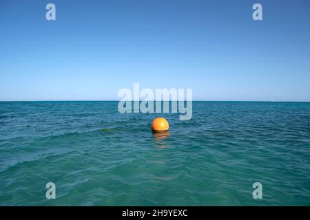 Bouée orange flottant sur les vagues de la surface de la mer.Concept de sécurité de la vie humaine. Banque D'Images