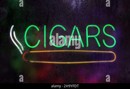 Affiche de cigare néon vintage dans la fenêtre à pluie humide Banque D'Images