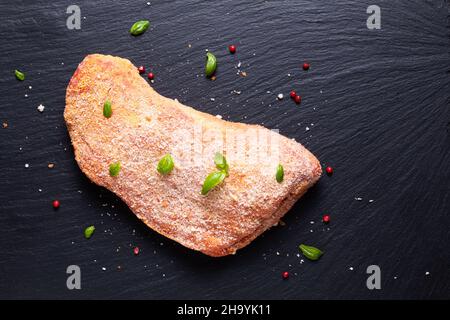 Concept alimentaire veau cordon bleu non cuit sur panneau en pierre d'ardoise noire avec espace de copie Banque D'Images