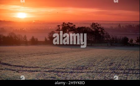 Lever du soleil en hiver avec le château de Windsor émergeant de la brume à l'horizon Banque D'Images