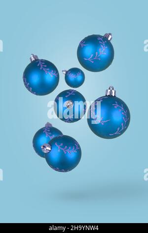 Boules de Noël volantes sur fond bleu vif.Joyeuses vacances.Nouveau concept minimal de l'année.Noël idée minimale. Banque D'Images