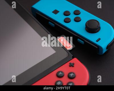 Tambov, Fédération de Russie - 28 septembre 2021 Nintendo Switch console de jeux vidéo avec un rouge joy-con en lui et un bleu joy-con à côté de lui. Banque D'Images