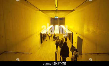 Londres, Grande-Bretagne-septembre 2019 : couloir public dans un bâtiment à la lumière jaune.Action.Transports publics souterrains avec un élégant lig jaune vif Banque D'Images