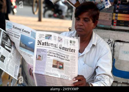 Un homme lisant le journal après que l'Inde ait perdu son premier chef d'état-major de la Défense (CEMD), le général Bipin Rawat, l'épouse Madhulika, 11 autres personnes dans un tragique accident mi-17V5 du broyeur de la FIA à Coonoor, dans le Tamil Nadu, à Karachi, le jeudi 09 décembre 2021. Banque D'Images