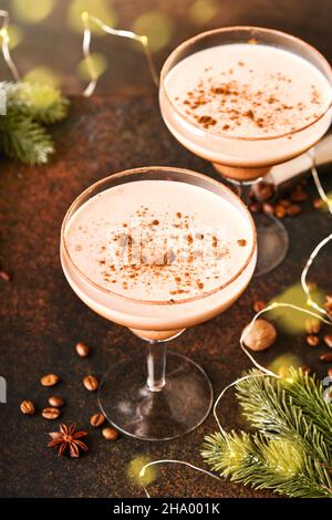 Alexander cocktail en verre cocktail sur table en bois avec shaker, noix de muscade et petit râpe avec décoration de Noël sur fond sombre.Photographie de boisson Banque D'Images