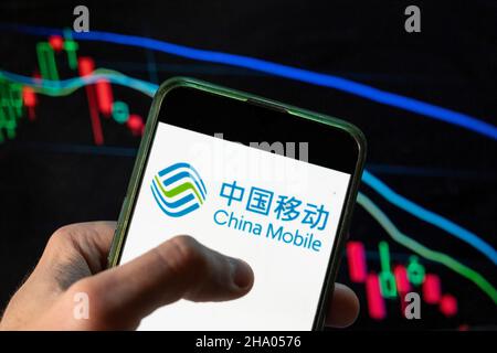 Chine.09th décembre 2021.Dans cette illustration, le logo China Mobile de la société de télécommunications publique chinoise est affiché sur un smartphone avec un graphique d'indice boursier économique en arrière-plan.(Photo de Budrul Chukrut/SOPA Images/Sipa USA) crédit: SIPA USA/Alay Live News Banque D'Images