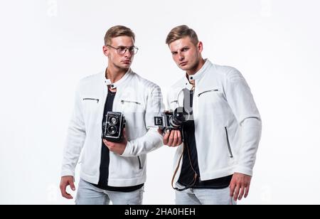 les deux frères hommes se ressemblent utilisent un appareil photo vintage pour photographier Banque D'Images