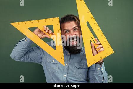 homme heureux avec la taille mesurée sur l'outil de mathématiques de règle de triangle, étude d'école Banque D'Images