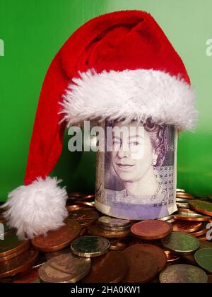 Lot de livres sterling en chapeau de père noël sur les pièces britanniques.Concept des économies de Noël Banque D'Images