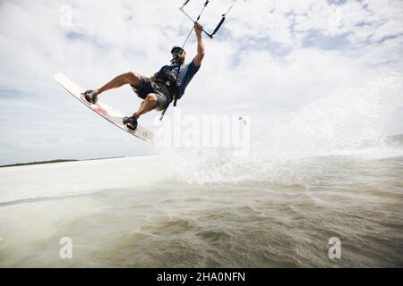 Un homme kiteboarding dans les clés de floride saute hors de l'eau Banque D'Images