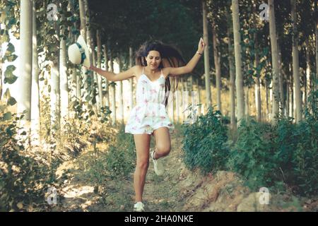 Young beautiful happy hispanic girl jumping tandis que profiter de son temps libre en contact avec la nature Banque D'Images