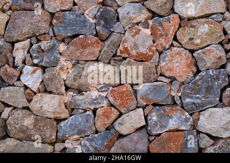 Arrière-plan texturé de mur de pierre fait de pierres multicolores naturelles.Gros plan Banque D'Images