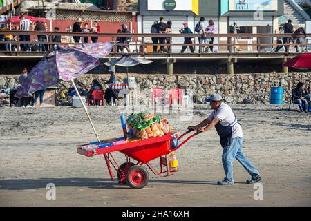 Un venteur mexicain pousse sa charrette chargée de légumes sur le sable de Tijuana Beach, (Playas de Tijuana) Baja California, Mexique. Banque D'Images