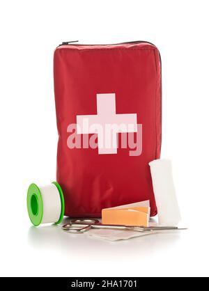 Sac rouge pour trousse médicale de premiers soins avec ciseaux, ruban adhésif et gants sur fond blanc Banque D'Images