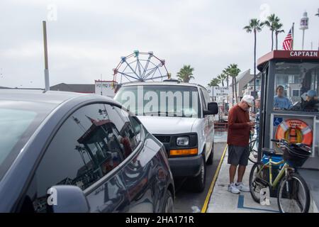 Un homme avec son vélo sur le ferry pour l'île de Balboa, Balboa, Californie. Banque D'Images