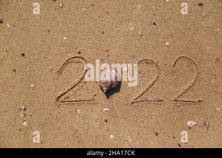 Mot 2022 écrit sur le sable d'une plage.Texte nouvel an 2022 sur la plage de la mer Banque D'Images