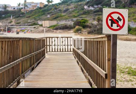 Rouge et noir, pas de chiens autorisés, panneau sur le chemin en bois menant à la plage Banque D'Images