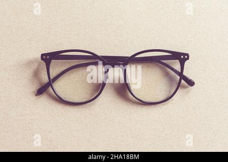 Lunettes en plastique recyclé sur fond de carton beige, revêtement plat minimaliste Banque D'Images