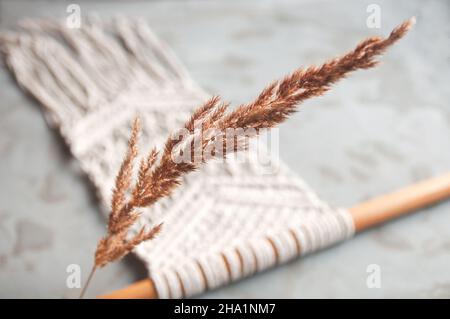 pelouse sèche sur le décor de mur d'arrière-plan dans le style boho macrame Banque D'Images