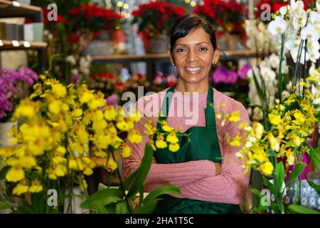 Femme vendeur posant avec des orchidées dans des pots Banque D'Images