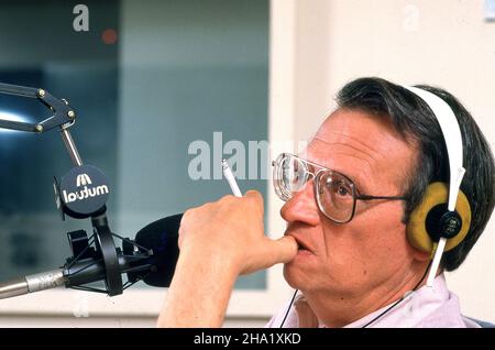 Bien avant CNN Larry King avait une émission de radio populaire qui a commencé tard et est allé pour la meilleure partie de la nuit.TIME magazine...Je me souviens que j'avais travaillé toute la journée pendant cette journée.J'ai photographié la première partie de l'émission de radio en restant à l'écart et en restant calme.King n'avait pas d'invités et c'était juste lui assis parlant dans ses microphones.J'ai été déterminé à rester jusqu'à la fin du programme juste au cas où une photo se produirait.Jusqu'à présent, rien et je suis allé dormir.King regarda, apporta un micro, me réveilla et commença à interroger le PHOTOGRAPHE DU MAGAZINE TIME. Banque D'Images