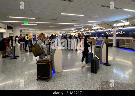 Les passagers s'enregistrent aux kiosques automatisés du comptoir de billetterie et de bagages de Southwest Airlines au terminal 1 de l'aéroport international de Los Angeles, le jeudi 9 décembre 2021, à Los Angeles. Banque D'Images