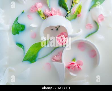 Coupes de porcelaine brisées et fleurs dans le lait, carte postale tendre Banque D'Images