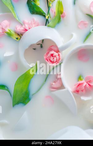 Coupes de porcelaine brisées et fleurs dans le lait, carte postale tendre Banque D'Images