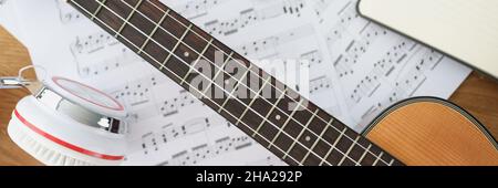 Casque de guitare en bois et notes de musique sur la table de clôture Banque D'Images