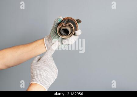 Main de mécanicien présente des défauts et de la corrosion sur la pièce de voiture - blocs silencieux de la bague arrière.Entretien et sécurité du châssis Banque D'Images