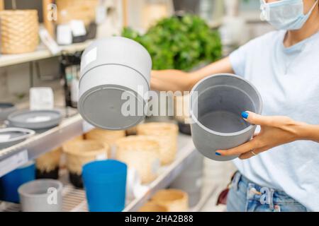 la femme choisit un pot pour les plantes dans un magasin de fleurs de détail pour le ménage Banque D'Images