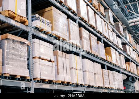 Grandes boîtes sur étagères, emballées dans du carton et du ruban adhésif dans un entrepôt d'expédition et de vente en gros.Produits de base et concept de stockage Banque D'Images