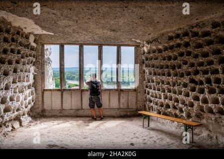 La Roche-Guyon (nord de la France) : troglodyte pigeonnaire du château creusé dans une falaise calcaire.Homme vu de derrière parlant une photo du paysage Banque D'Images