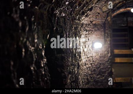 Vieux mur de loft en brique dans le sous-sol militaire secret.Ancienne cave à vin, passage de manoir.Ancien fort allemand d'époque avec éclairage tamisé et murs de briques, Banque D'Images