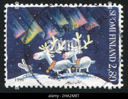 FINLANDE - VERS 1996: Timbre imprimé par la Finlande, montre des lapins et des rennes observant les aurores boréales, vers 1996 Banque D'Images