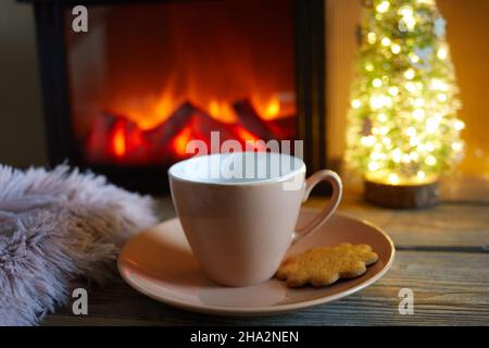 Tasse avec couverture au-dessus de la cheminée sur une table en bois.Concept de vacances d'hiver et de Noël Banque D'Images