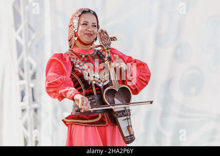 06 juillet 2021, Ufa, Bashkortostan, Russie : une femme se produit sur la scène d'un festival folklorique et joue le kobyz, un instrument turc à cordes Banque D'Images