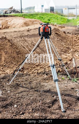 Le dispositif laser à odolite sur trépied qui mesure la distance et les angles sur le sol, est nécessaire pour la construction de routes et de bâtiments Banque D'Images