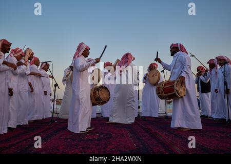 Danse traditionnelle du folklore du Qatar (danse de l'Ardah) à Katara onzième festival traditionnel de dhow à Doha Qatar vue au coucher du soleil Banque D'Images