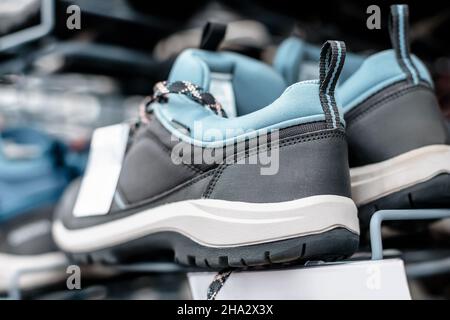 Chaussures de randonnée modernes en matériaux synthétiques avec membrane respirante et imperméable sur le comptoir du magasin Banque D'Images