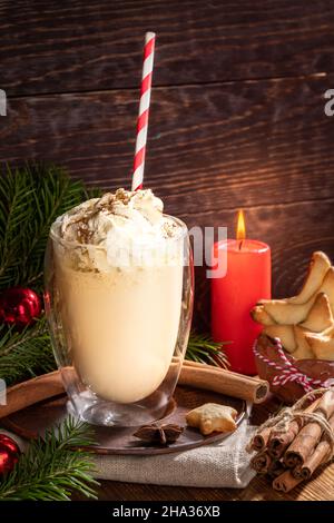 Aubergine de Noël avec crème fouettée en verre sur fond de bois.Confortable composition de Noël avec bougie rouge, branches de sapin, biscuits au gingembre .Christm Banque D'Images