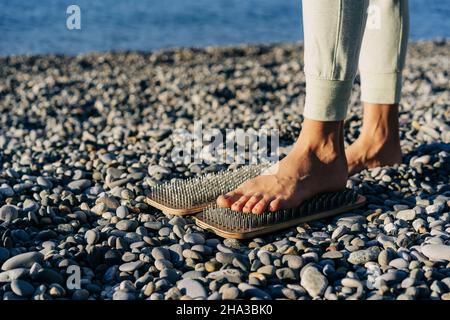 Une femme méconnaissable se tient sur un tableau avec des ongles, la pratique spirituelle de l'acupuncture et du yoga Banque D'Images