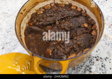 Un four hollandais jaune avec des côtes de bœuf braisées maison au vin et à l'ail Banque D'Images