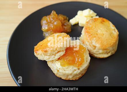 Scones à écorce d'orange confits appétissants avec beurre et marmelade d'orange Banque D'Images