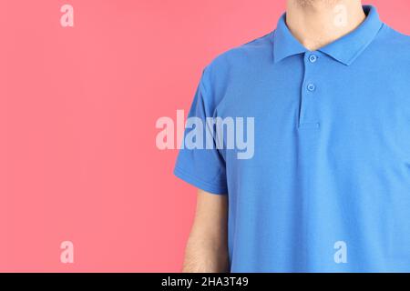 Homme dans un polo blanc bleu sur fond rose Banque D'Images