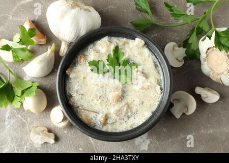 Concept de nourriture savoureuse avec sauce aux champignons sur fond gris texturé Banque D'Images