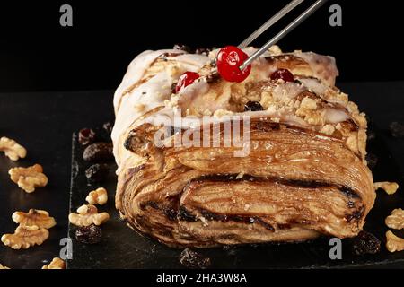 Délicieux strudel aux pommes avec des noix, des raisins secs et des cerises en gelée Banque D'Images
