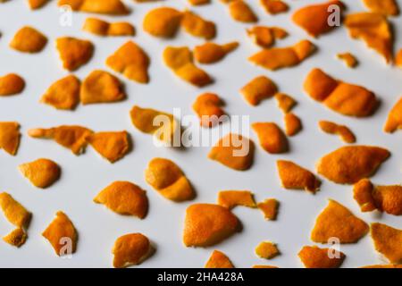 Effet de flou artistique sur le fond de Noël. Des couleurs orange et mandarine modernes et tendance sur un fond blanc.Beaucoup de petits morceaux de pelure séchée.Répétition.Isolé.O Banque D'Images